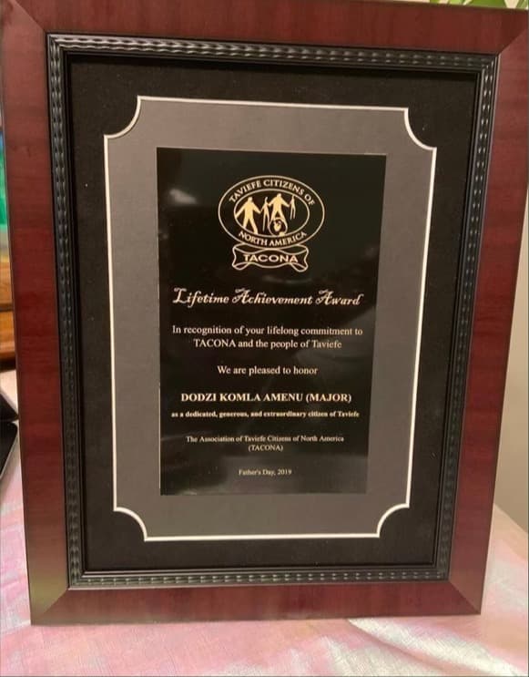 Close-up of the engraved Lifetime Achievement Award plaque honoring Mr. Dodzi Komla Amenu