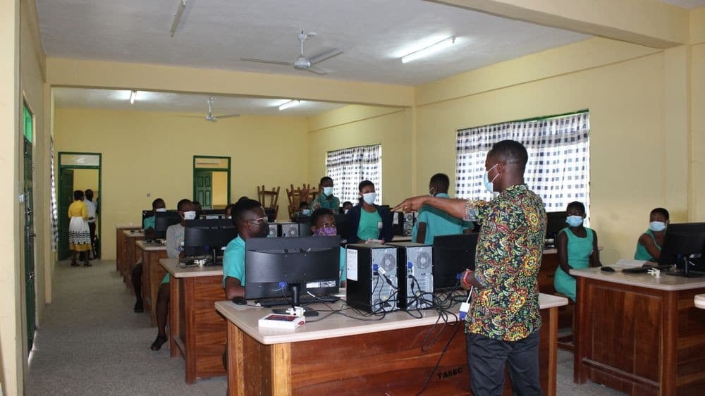 Wide view of the TASEC ICT lab with students at HP desktops and a teacher giving instructions