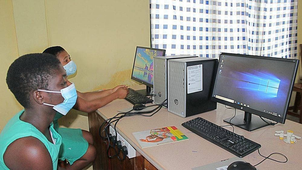 Two TASEC students working at an HP desktop computer in the new lab